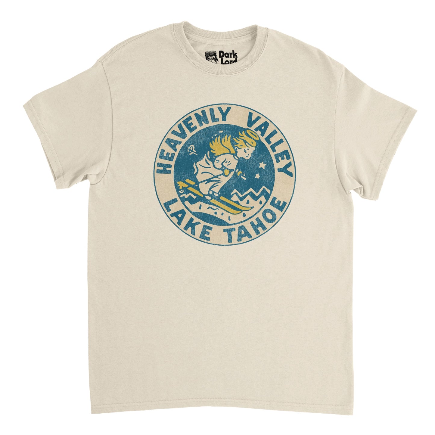 A soft cream colored 80s style retro t-shirt that says "Heavenly Valley Lake Tahoe", referencing the famous ski and snowboard resort Heavenly Mountain Resort on the shores of Lake Tahoe in the Sierra Nevada Mountain Range on the border of California and Nevada. Includes a vintage logo of an angelic figure skiing down a mountain with golden wings, hair, skis, and halo, small stars and mountain peaks dotting the background.
