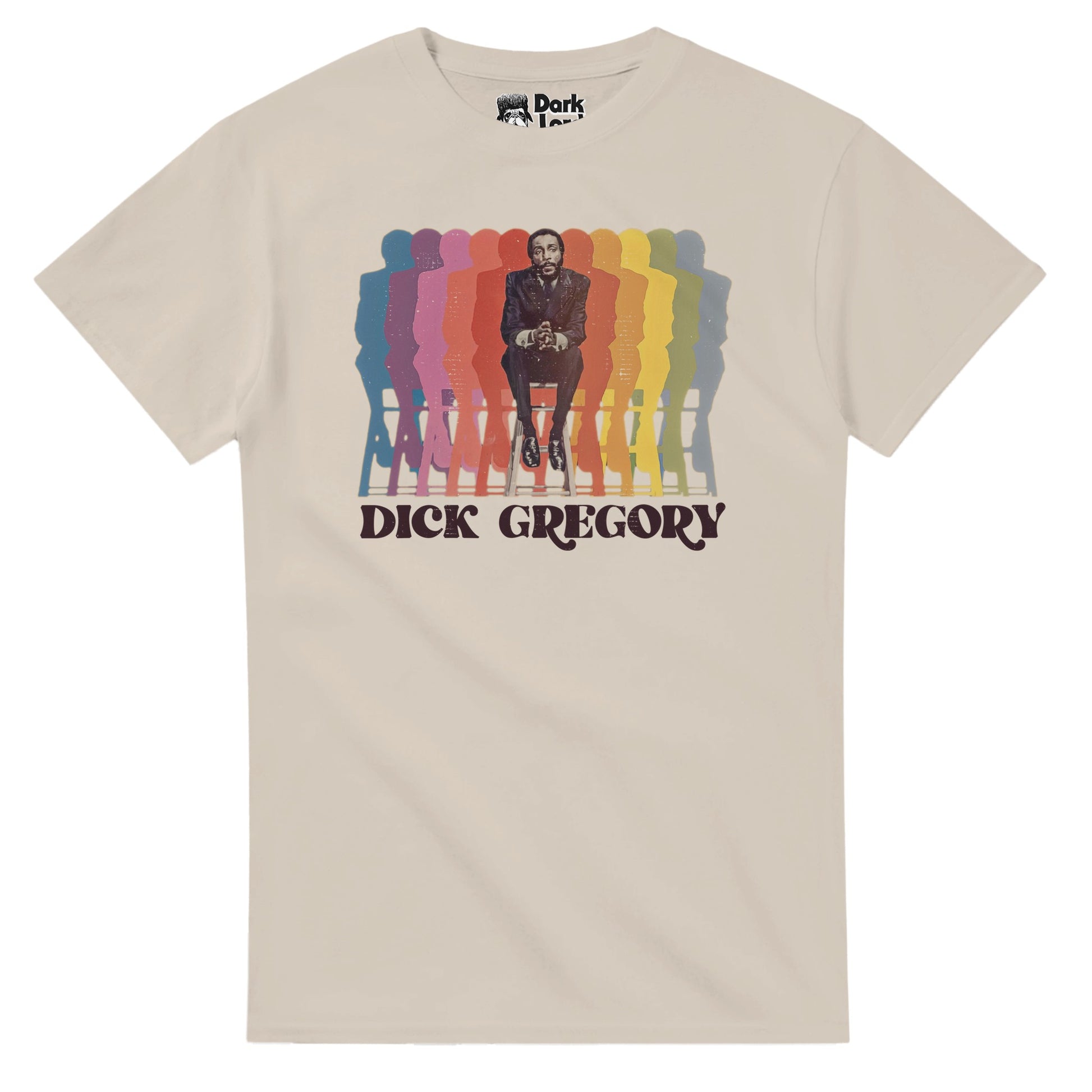A vintage, sand colored souvenir t-shirt with an image of Dick Gregory sitting on a bench, hands clasped, next to multiple colorful reflections of himself and above his name: "Dick Gregory". In reference to the famous comedian, actor, writer, social critic, and activist against racial injustice and for feminism and animal rights, popular in the 1960s for his comedy and no-holds-barred humor sets, popular across the United States and in the African American community, especially in the Southern US. 