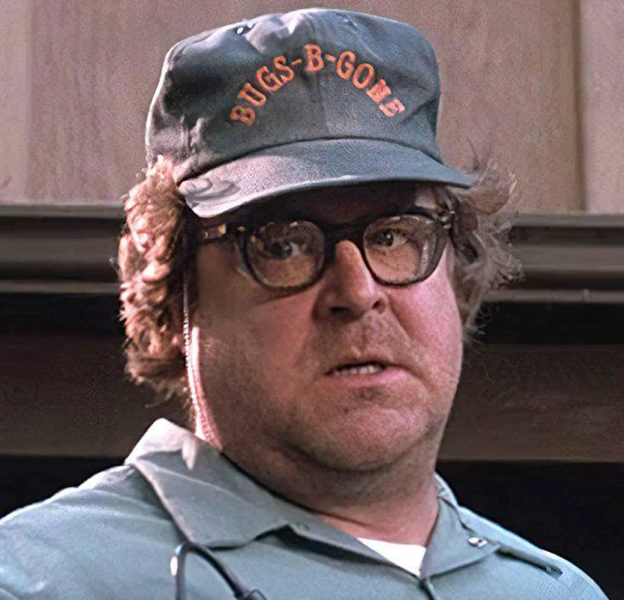 A man wearing a baseball cap with the text "BUGS-GONE" on it, along with glasses, is shown in the image.