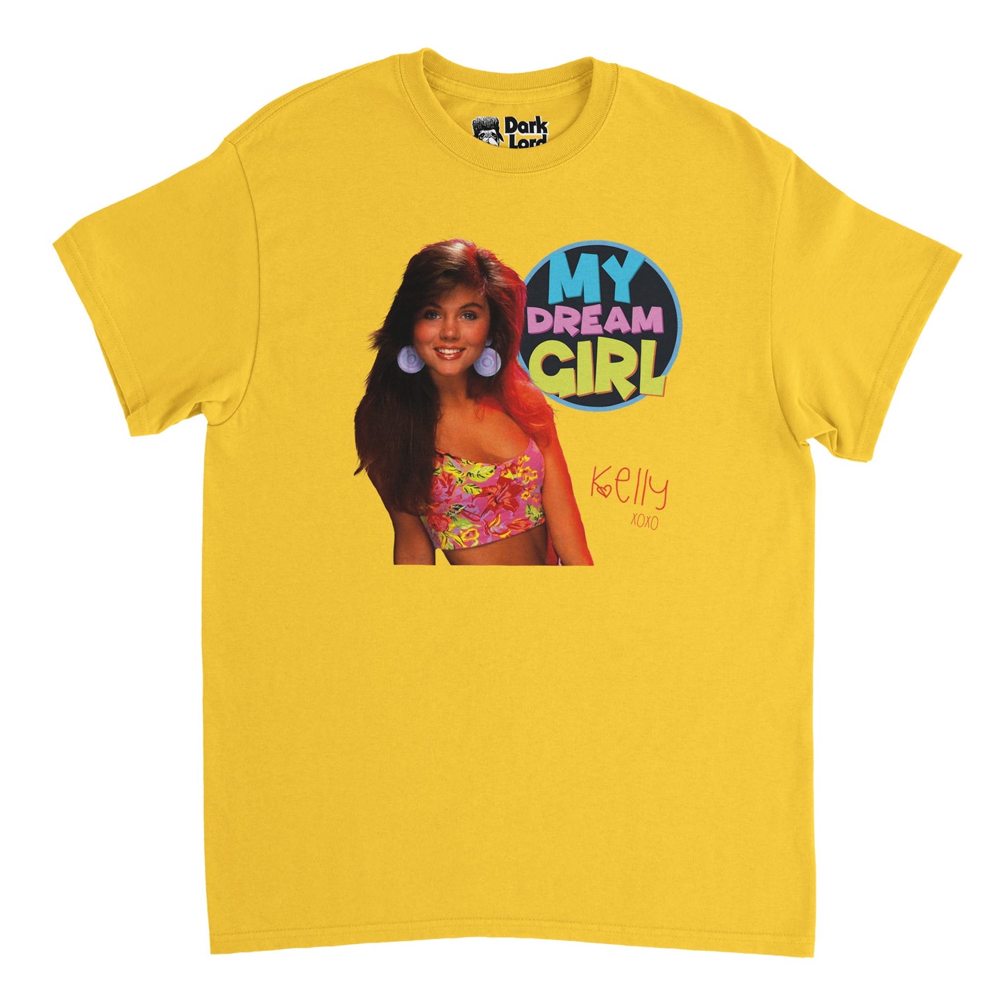 A vintage, 70s style t-shirt in yellow which says "My Dream Girl" in bold, blue, pink, and yellow letters and "Kelly XOXO" in pink with a small heart by the "K". Includes an image of the Saved by the Bell character Kelly Kapowski, played by iconic actress Tiffani Amber Thiessen, wearing a flowered pink and yellow top and large round purple earrings.