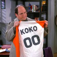 A man is holding up a shirt with the number "00" on it.