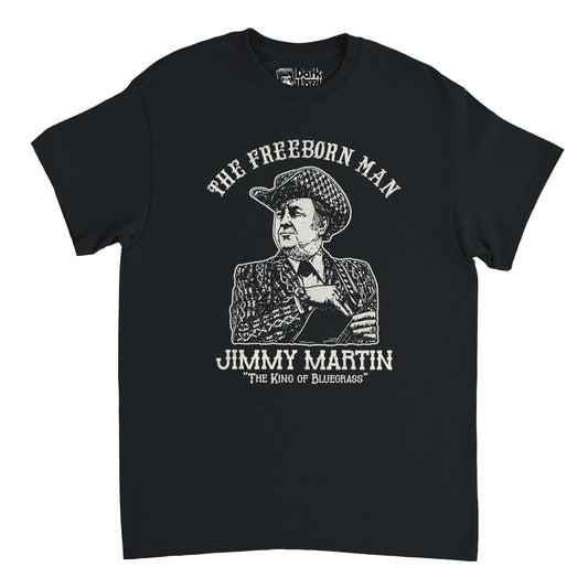 A retro, 70s style black colored t-shirt that says "The Freeborn Man," referencing the 1969 album, above an image of the world famous American singer and musician Jimmy Martin, known as "The King of Bluegrass", wearing a checkered cowboy hat and patterned suit and tie, holding his guitar. 