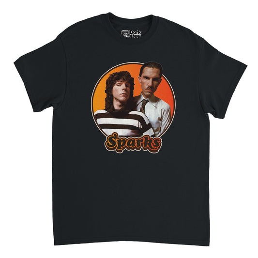 A black colored, 80s style retro t-shirt that says "Sparks" in hombre yellow/orange outlined bubble letters. Has an image of the two brothers Ron and Russell Mael from the popular cult pop-rock band Sparks, one with long hair wearing a striped black and white shirt, the other a tie on a crisp white button up, on top of an hombre yellow to orange circular backdrop, known for their song 'This Town Ain't Big Enough for Both of Us' and for the documentary "The Sparks Brothers".  